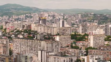 Yeşil tepeler ve dağlara karşı Sovyet blokları ve modern binalarıyla Tiflis şehri