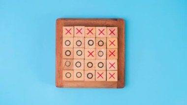 Tahta masa tic-tac-toe 'nun hareketli animasyonunu durdurun. Mavi arka planda X-O ve ortadaki harflerin dönüşümü birbirinden farklı..