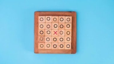 Tahta masa tic-tac-toe 'nun hareketli animasyonunu durdurun. Mavi arka planda X-O ve ortadaki harflerin dönüşümü birbirinden farklı..