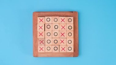 Tahta masa tic-tac-toe 'nun hareketli animasyonunu durdurun. Mavi arka planda X-O ve ortadaki harflerin dönüşümü birbirinden farklı..