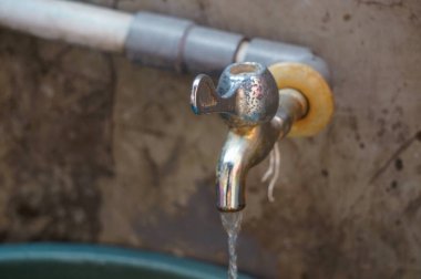 Su eski paslı demir musluktan geliyor.