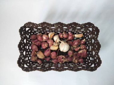 Mutfak baharatları soğan ve sarımsak sepette yalıtılmış beyaz arka plan