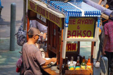 Jakarta 25 Eylül 2023 - Tavuklu erişte hazırlayın. Köfteli tavuklu şehriyeci müşteriler için tavuklu erişte yapıyor..