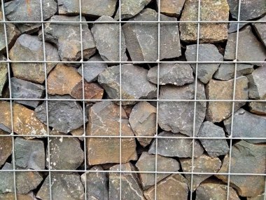 Metal kabloyla örülü taş bir duvarı kapat..