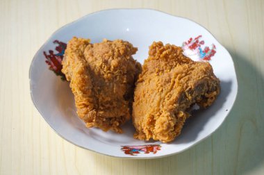 Beyaz bir tabak içinde çıtır kızarmış tavuk