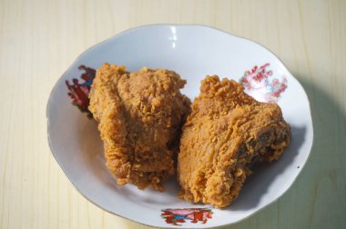 Beyaz bir tabak içinde çıtır kızarmış tavuk