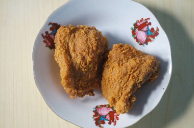 Beyaz bir tabak içinde çıtır kızarmış tavuk