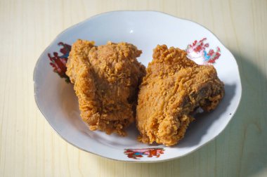 Beyaz bir tabak içinde çıtır kızarmış tavuk