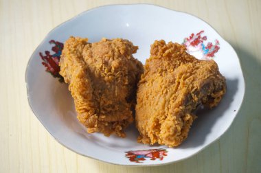 Beyaz bir tabak içinde çıtır kızarmış tavuk