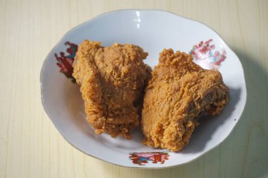 Beyaz bir tabak içinde çıtır kızarmış tavuk