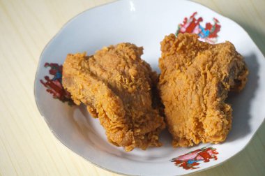 Beyaz bir tabak içinde çıtır kızarmış tavuk