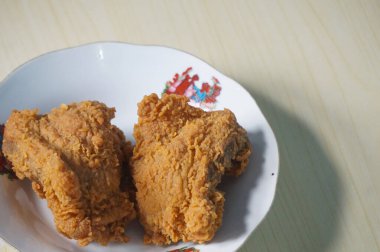 Beyaz bir tabak içinde çıtır kızarmış tavuk