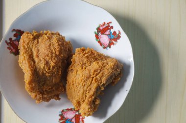 Beyaz bir tabak içinde çıtır kızarmış tavuk