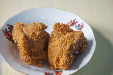 Beyaz bir tabak içinde çıtır kızarmış tavuk