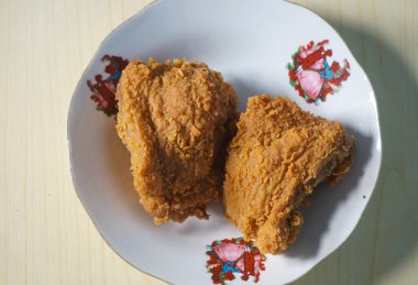 Beyaz bir tabak içinde çıtır kızarmış tavuk