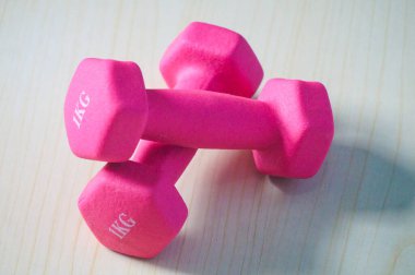 Two pink 1kg dumbbells. Weights for a fitness training. clipart