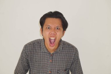 Beyaz arka planda izole edilmiş siyah gömlekli genç Asyalı adamın yüzü şaşırtıcıydı..