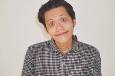 Siyah gömlekli, beyaz arka planda izole Asyalı genç bir adamın gülümseyen yüzü..