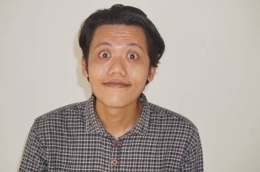 Siyah gömlekli, beyaz arka planda izole Asyalı genç bir adamın gülümseyen yüzü..