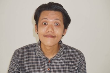 Siyah gömlekli, beyaz arka planda izole Asyalı genç bir adamın gülümseyen yüzü..