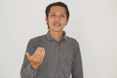 Asyalı genç adam ayakta duruyor ve gülümsüyor.