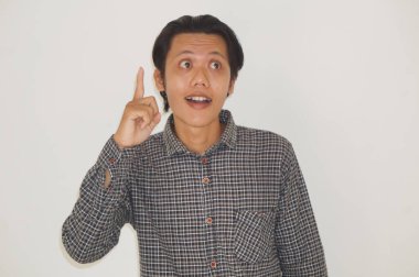 Siyah tişörtlü genç Asyalı adam mutlu bir şekilde elini kaldırdı.