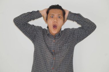 Beyaz arka planda siyah gömlekli Asyalı genç adamın şaşırmış ifadesi..