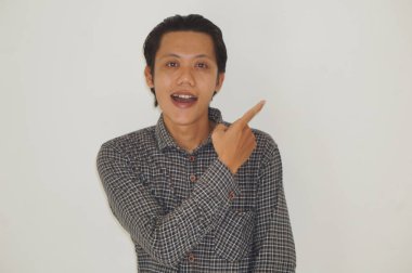 Siyah tişörtlü genç Asyalı adam gülümsüyor.