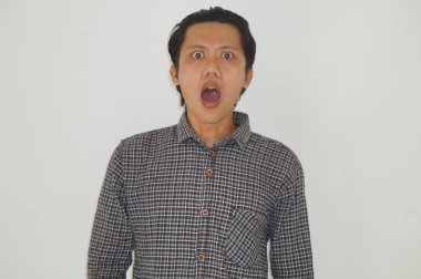 Beyaz arka planda siyah gömlekli Asyalı genç adamın şaşırmış ifadesi..