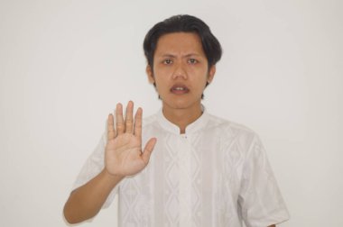 Beyaz tişörtlü genç Asyalı yakışıklı adam dur hareketi yapıyor.