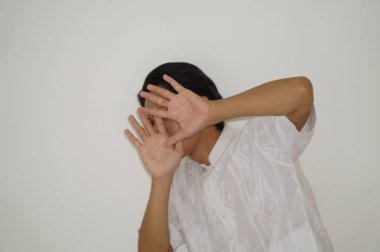 Beyaz gömlekli Asyalı genç adamın beyaz arka planda izole edilmiş yüz ifadesi.