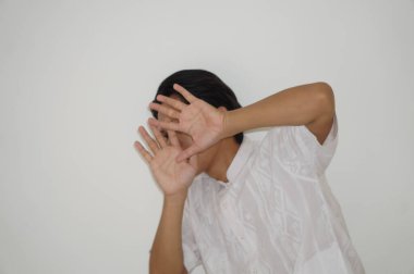 Beyaz gömlekli Asyalı genç adamın beyaz arka planda izole edilmiş yüz ifadesi.