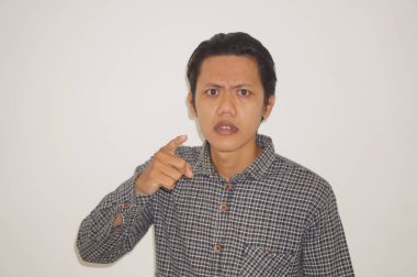 Siyah tişörtlü genç Asyalı adam kamerayı göstererek kızgın.