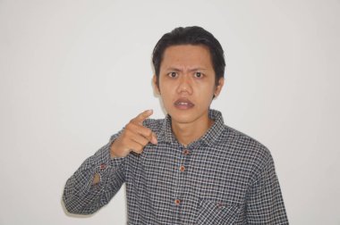 Siyah tişörtlü genç Asyalı adam kamerayı göstererek kızgın.