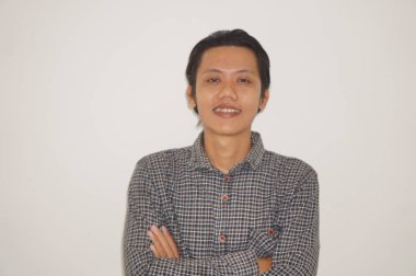 Siyah gömlekli kameraya gülümseyen genç Asyalı adam.