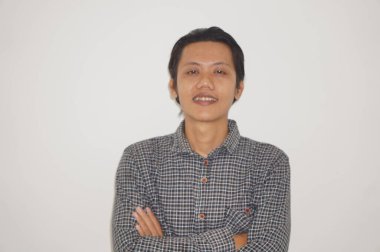 Siyah gömlekli kameraya gülümseyen genç Asyalı adam.