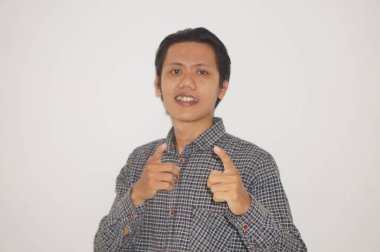 Siyah gömlekli genç Asyalı adam kamerayı göstererek mutlu ve gülümsüyor..