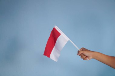 Endonezya bayrağının sembolü olarak kırmızı ve beyaz bir bayrak tutuyor. Endonezya 'nın bağımsızlık günü kavramı