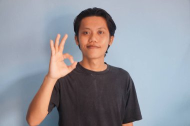 Rahat bir pozdaki Asyalı genç adamın portresi.