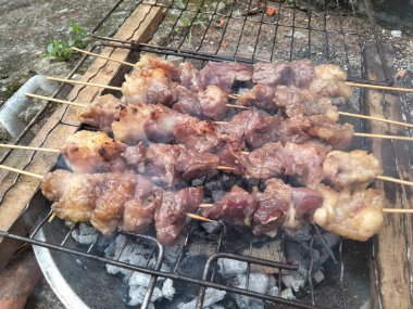 Mangal kömürü üzerinde ızgara sulu biftek. Popüler bir açık hava yemek etkinliği