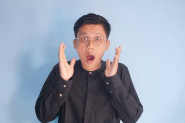 Siyah gömlekli genç Asyalı adamın şaşırmış ifadesi.