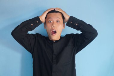 Asyalı genç bir adamın iki eli de başında siyah bir gömlek giymesine şaşırdım.