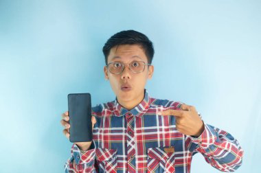 Şaşırmış genç Asyalı adam, kırmızı gömlek ve gözlük takıyor, şaşırmış yüz ifadesi, boş ekran kopyası alanı gösteriyor.