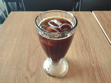 Yakın çekim - bir bardak buzlu kahve ahşap masada.