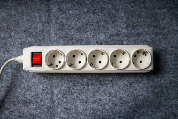 Power Strip with Switch: Multi-Socket Outlet for Electrical Appliances on a gray background