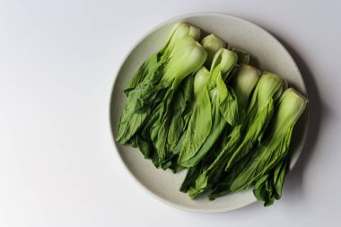 Fresh bok choy or pak choi or pakcoy on white plate clipart