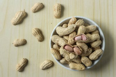 Ahşap bir arka planda kabuktaki soyulmamış fıstıklar.