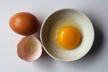 Kırık ve beyaz arka plan üzerinde bütün tavuk yumurta