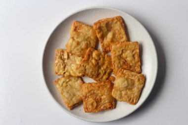 Beyaz bir tabakta kızarmış tempeh, Endonezya 'nın popüler sokak yemeklerinden biri..