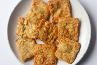 Beyaz bir tabakta kızarmış tempeh, Endonezya 'nın popüler sokak yemeklerinden biri..